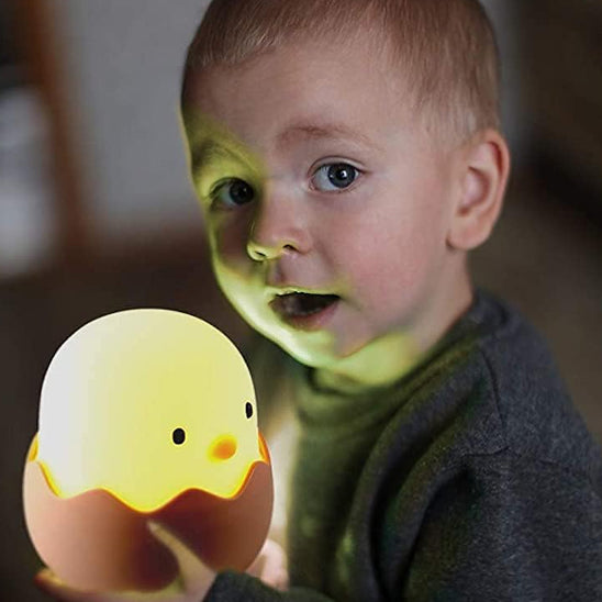 l_enfant est content avec la veilleuse enfant en forme de coquille d'ouf